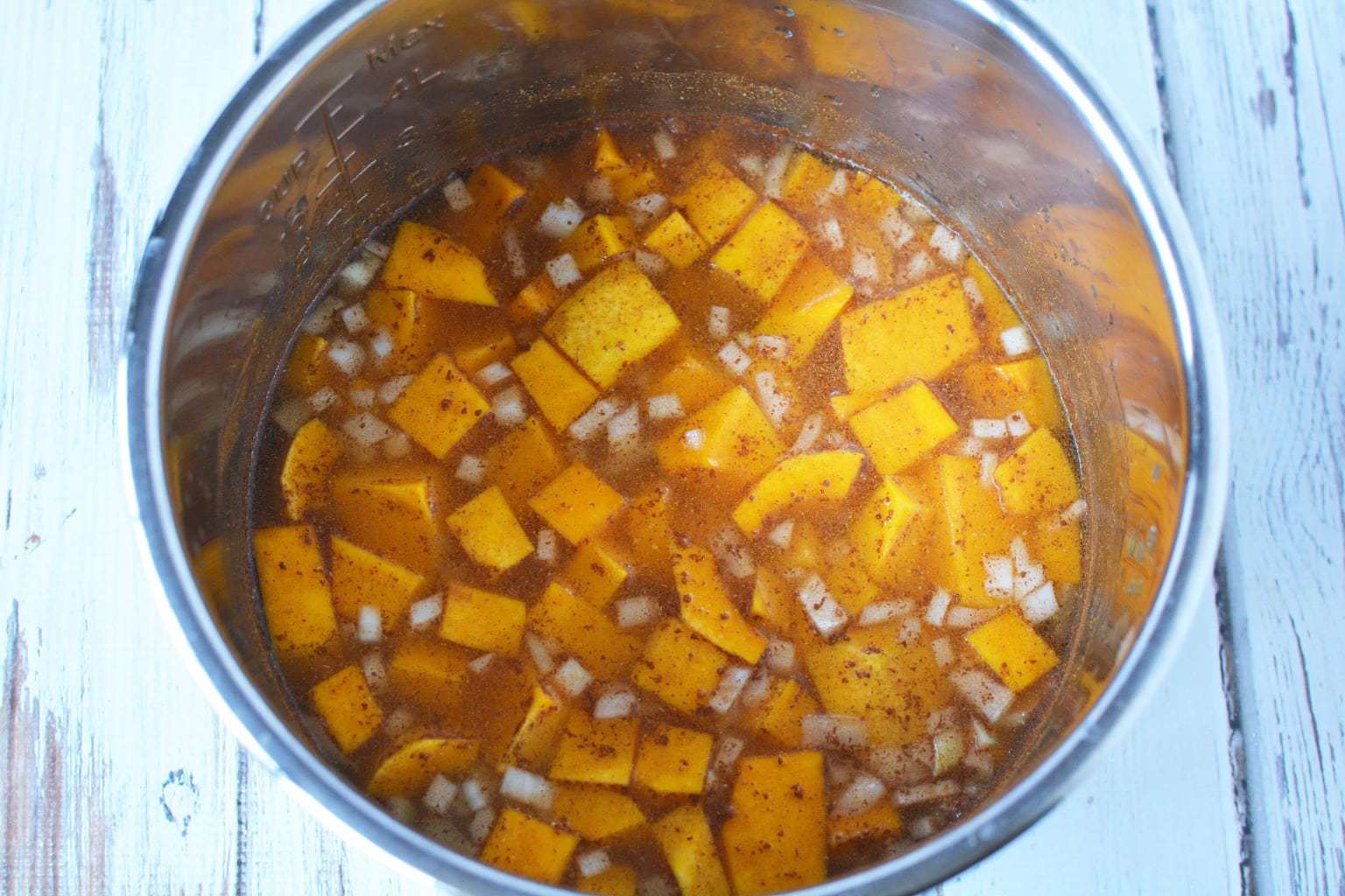 chopped butternut squash and diced onions in pot