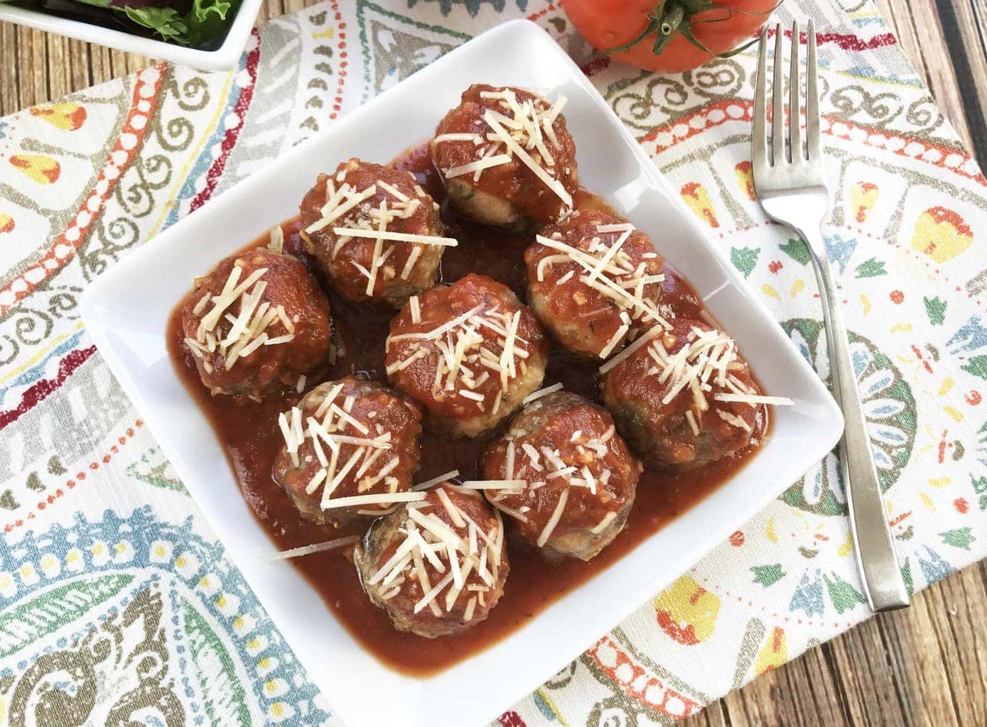 keto meatballs served on a white dish topped with parmesan