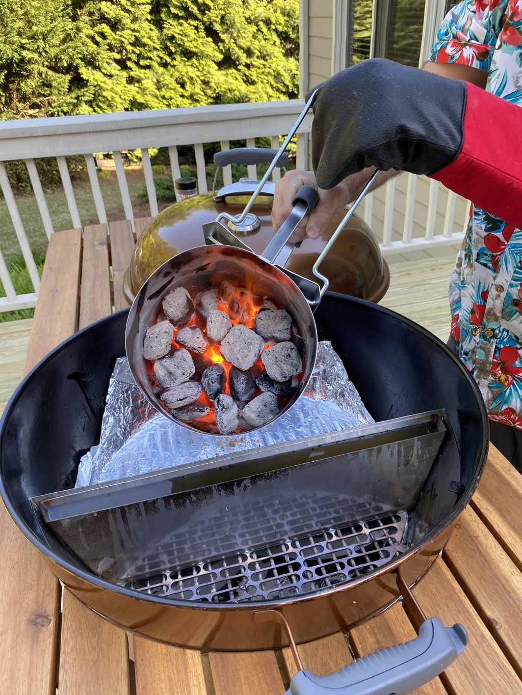 man pouring charcoal on grill