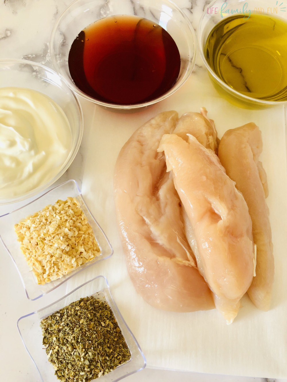 raw chicken and various seasonings in glass containers