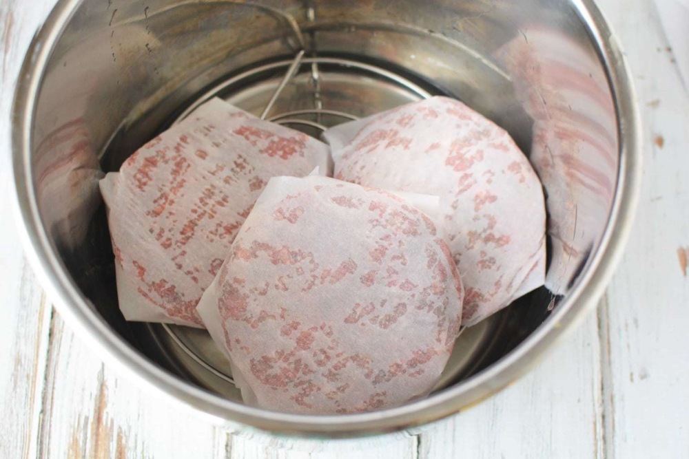 patties wrapped in parchment paper inside pot
