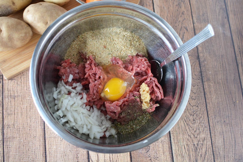 ground beef egg chopped onion and seasonings in a bowl