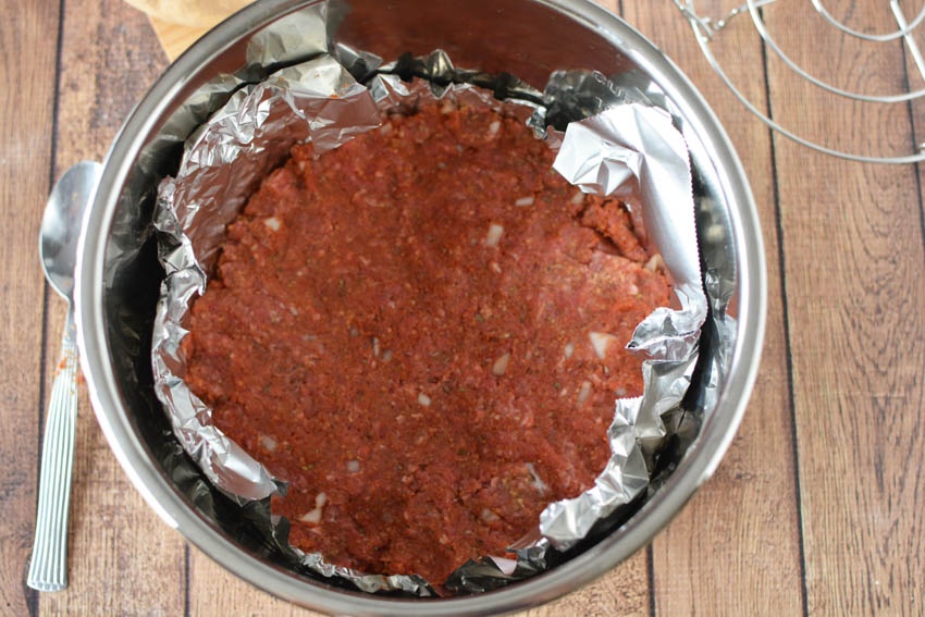 ground beef mixture flattened onto foil in pot
