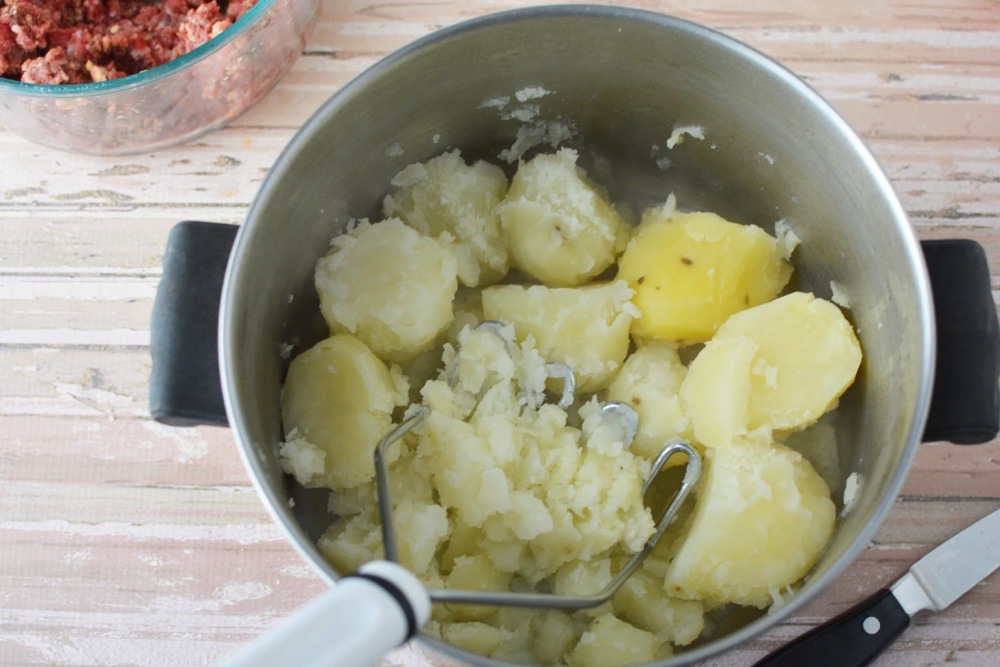 mashing potatoes in pot