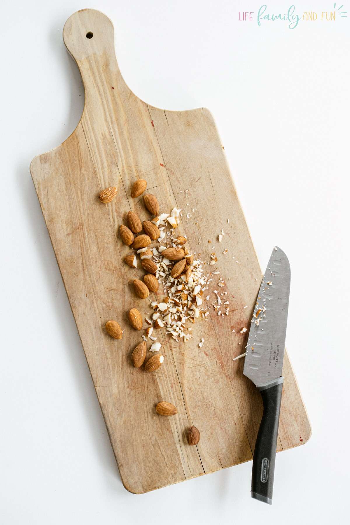 chopping almonds on cutting board with knife
